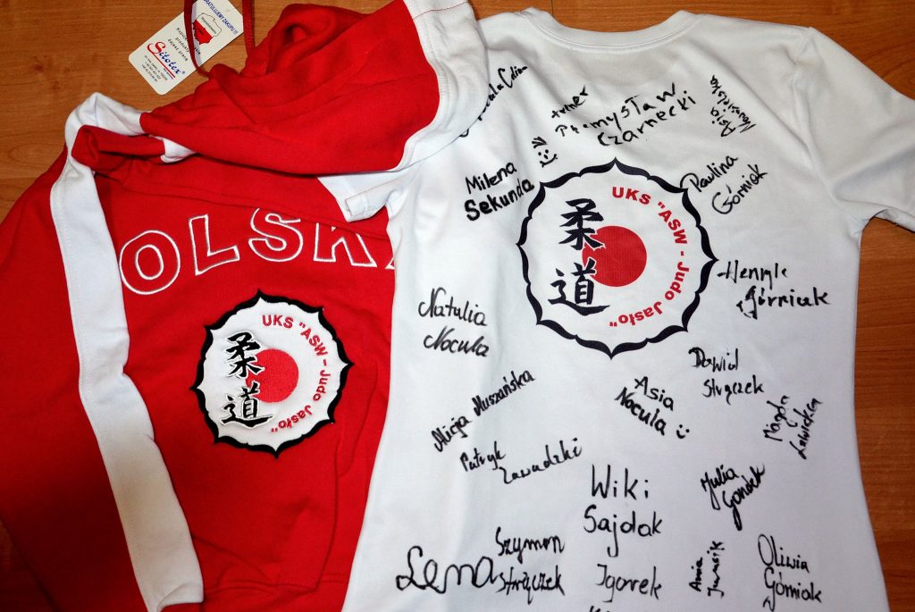 Klubowy dziecięcy dres wraz z koszulką klubu UKS Akademia Sportów Walki Judo-Jasło. Na koszulce - autografy jasielskich judoków, medalistów Mistrzostw Polski w Judo.